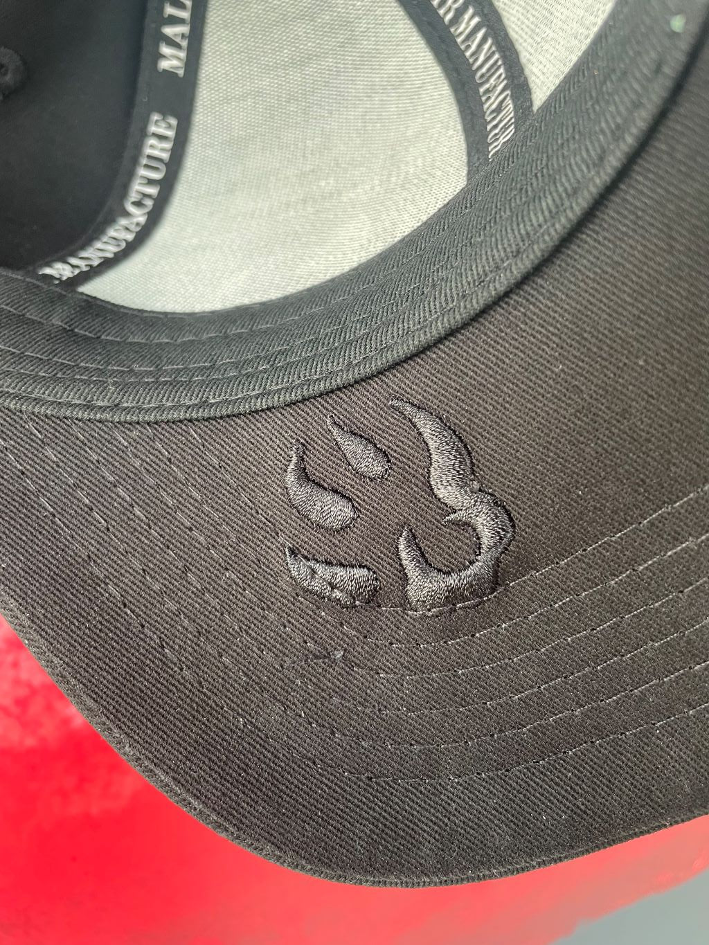 Vue du logo "patte de chien" en gros plan sur le dessous de la visière