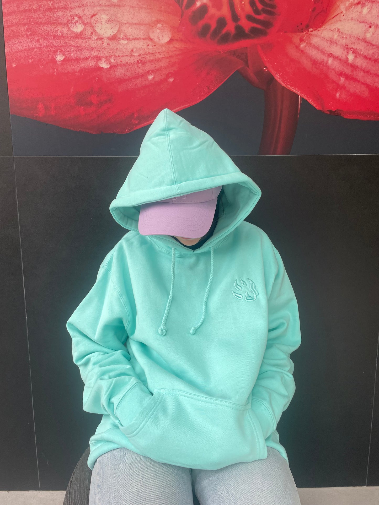mannequin portant un sweat couleur turquoise, capuche sur la tête