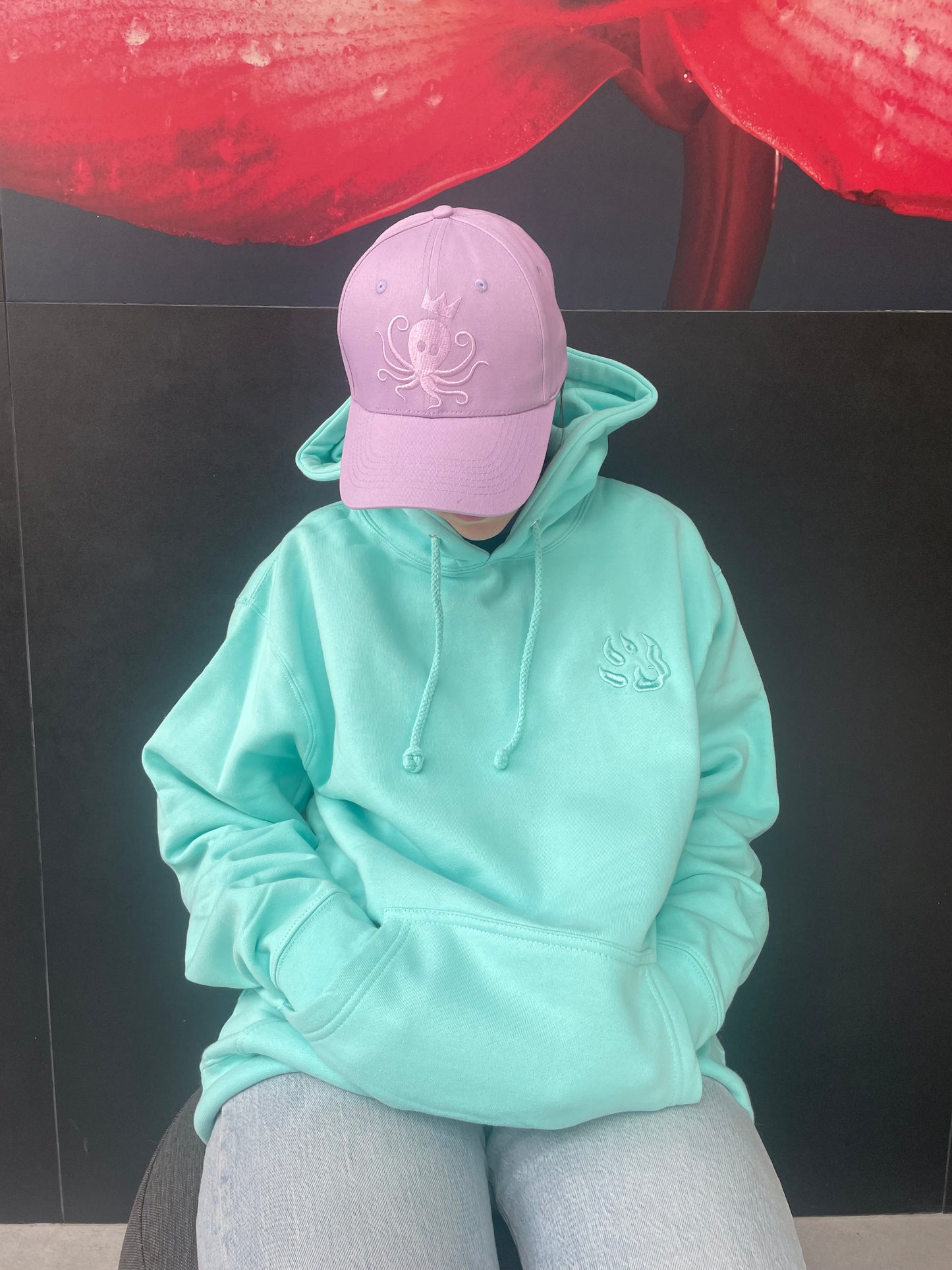 mannequin portant un sweat couleur turquoise, capuche sur les épaules